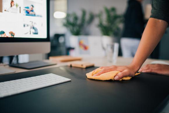 man cleaning desk in office