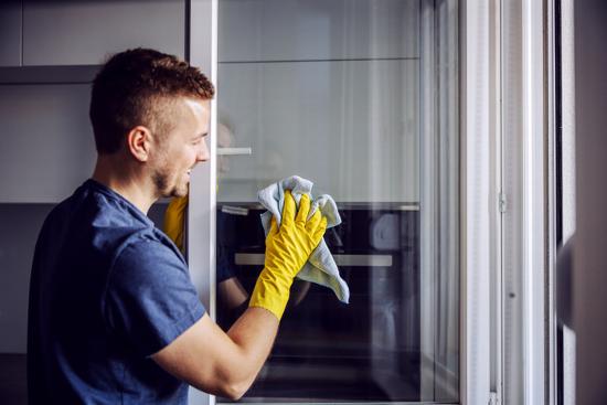 man cleaning windows in property