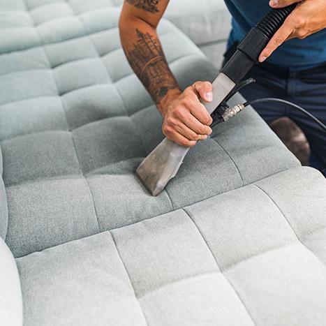 man cleaning sofa